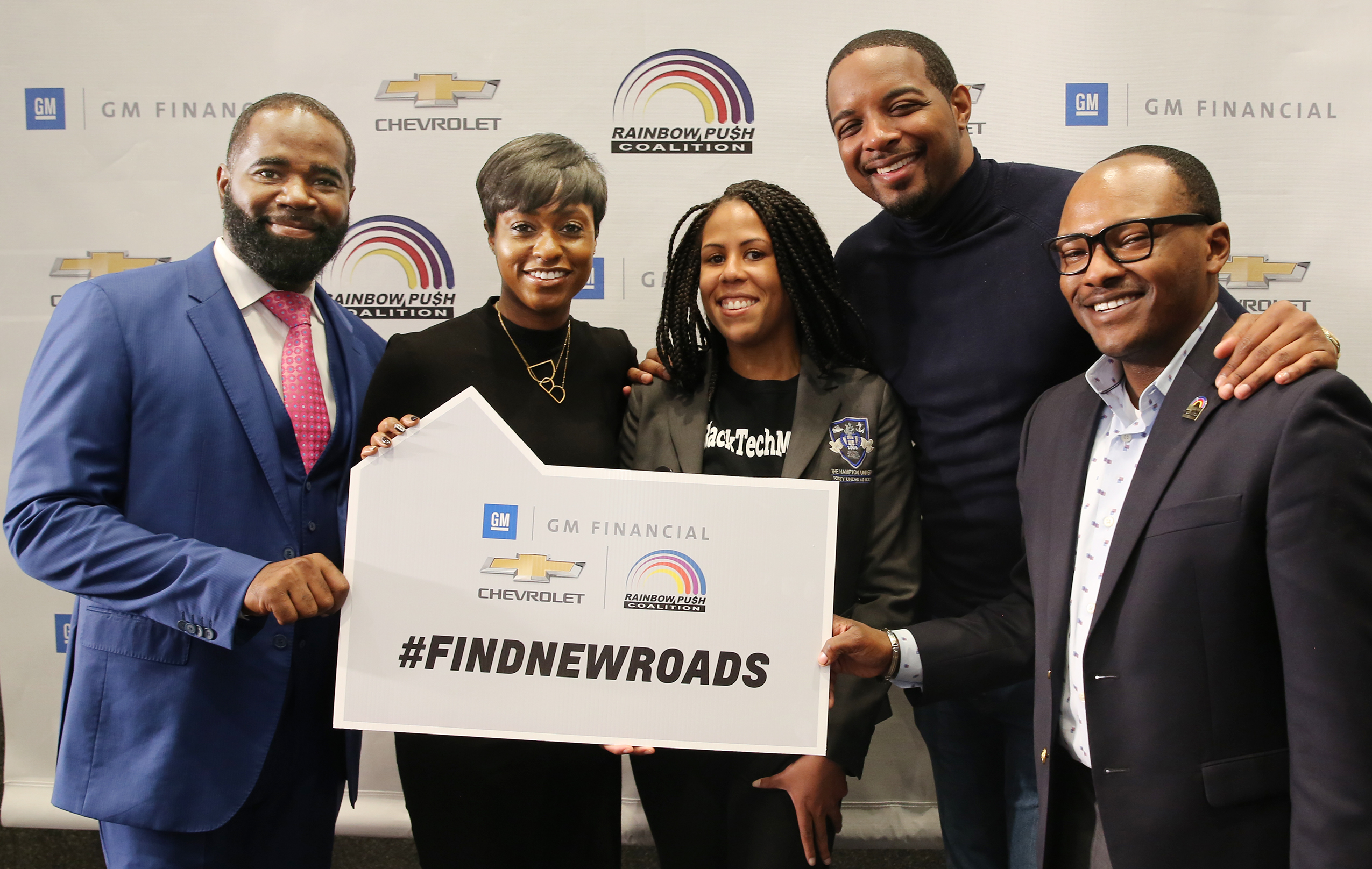 Group photo with #FINDNEWROADS sign at Money Matters